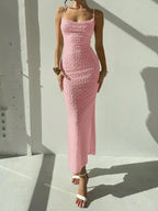 Elegant and romantic long dress for ladies with thin shoulder straps, a cinched waist and a slim figure, made of textured fabric